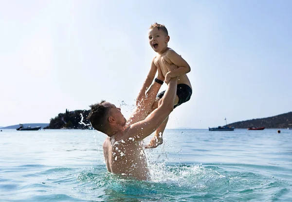 Baba ve oğul denizde oynuyorlar. Baba oğlunu fırlatır.. 