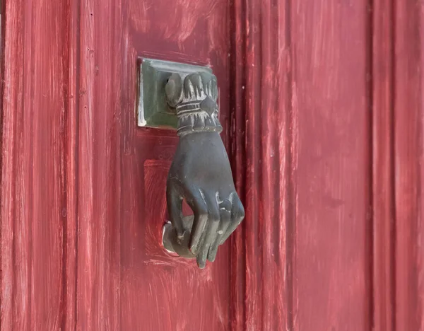 Deurknop in de vorm van een vrouwenhand op een rode deur in Griekenland — Stockfoto