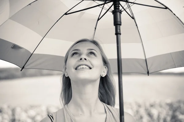 Menina bonita alegre segurando guarda-chuva no fundo do campo de girassol — Fotografia de Stock