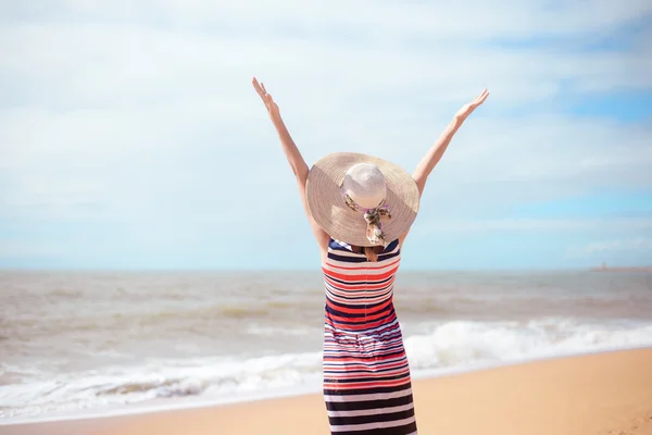 Rückansicht der romantischen Dame, die den Sommerstrand und die Sonne genießt und auf dem Meer winkt. Konzept von Gefühl und Freiheit — Stockfoto