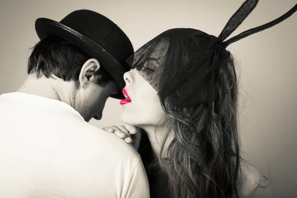 Black white of beautiful young lady wearing bunny ears whispering to man — Stock Photo, Image