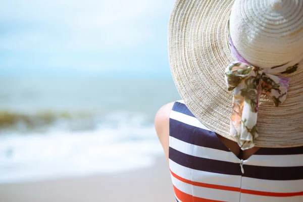 Widok z elegancki piękna kobieta w sukni i Słomkowy kapelusz z tyłu na plaży. — Zdjęcie stockowe