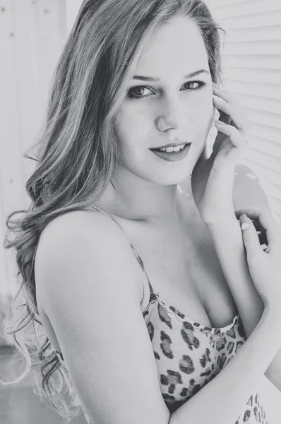 Fekete fehér Vértes boldog, relaxáló át ablak redőnyök szórakozik fiatal csinos hölgy portréja — Stock Fotó