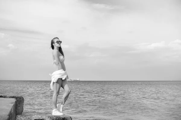 Czarno-biała fotografia pięknej młodej damy z widokiem na morze na tle nieba wody na zewnątrz. Portret — Zdjęcie stockowe