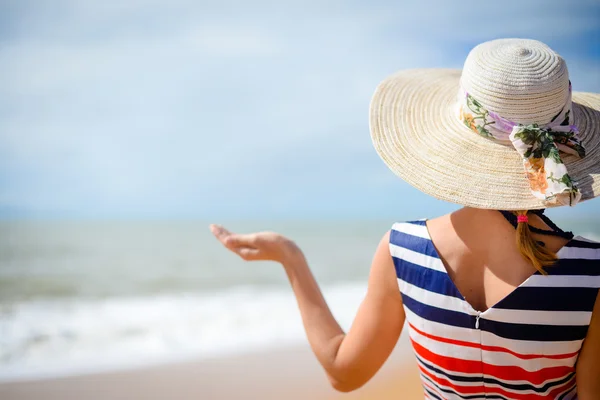 Bakifrån av elegant kvinna håller hand palm upp med sommaren havet i bakgrunden — Stockfoto