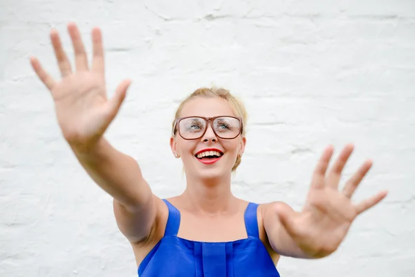 Portrait of happy beautiful blonde girl throws up her hands in grabbing move — Stock Photo, Image