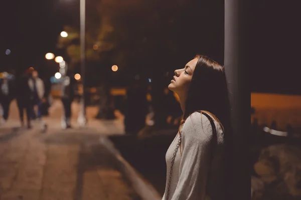 Πορτρέτο του όμορφη νεαρή κοπέλα κοιτώντας ψηλά, πόλη δρόμο τη νύχτα, το βράδυ τα φώτα bokeh φόντο σε εξωτερικούς χώρους — Φωτογραφία Αρχείου