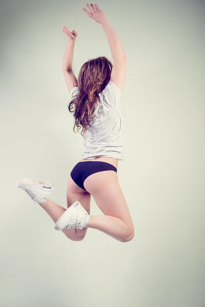 Picture of sexy beautiful girl with perfectly fit body jumping high on light copy space background — Stock Photo, Image