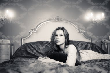 siyah ve beyaz lüks zemin üzerine yatakta yalan rahatlatıcı güzel genç bayan portresi