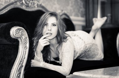 siyah ve beyaz koltukta yalan rahatlatıcı güzel genç bayan portresi 