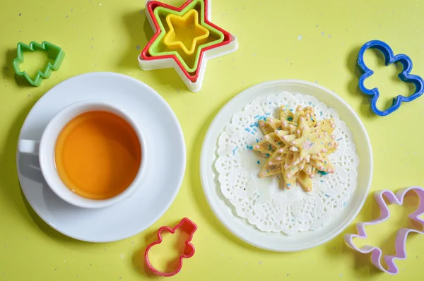 Immagine di biscotti su piastra bianca con stampi e tazza di tè — Foto Stock