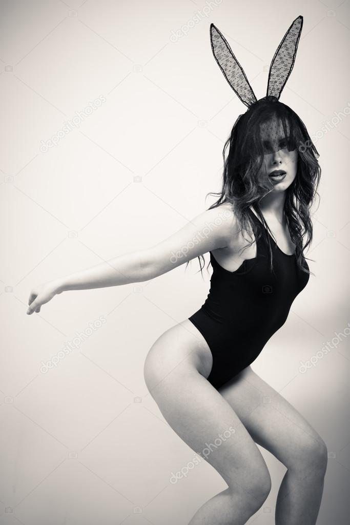 Portrait of sexy young beautiful woman in bunny ears mask and aerobic outfit happy posing