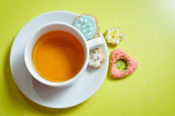 Närbild av ingefära cookies och kopp te på ljusgrön bakgrund — Stockfoto