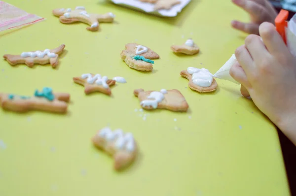 Little hand which is decorating Christmas gingerbread — Stock Photo, Image