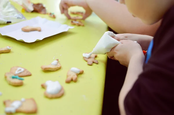 Close up on little kid decorating Christmas gingerbread — Stock Photo, Image