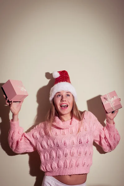 Exciting pretty girl in Santa hat with gifts — Stock Photo, Image