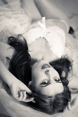 Beautiful bride in white lingerie relaxing in bed