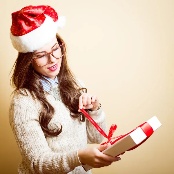 Holding present box beautiful young lady in Christmas hat — Stockfoto