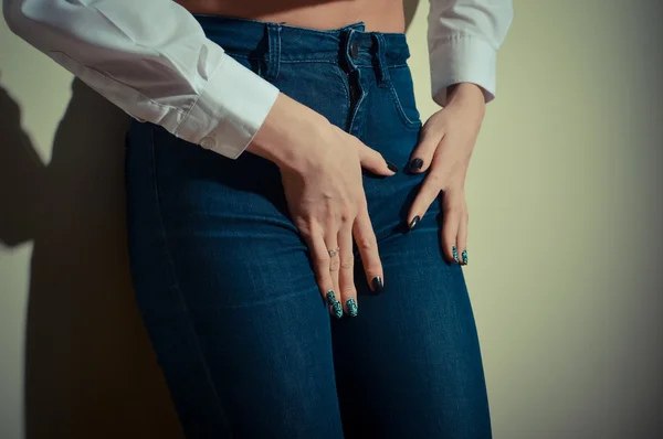 Pretty female shape with hands on hips wearing jeans — Zdjęcie stockowe