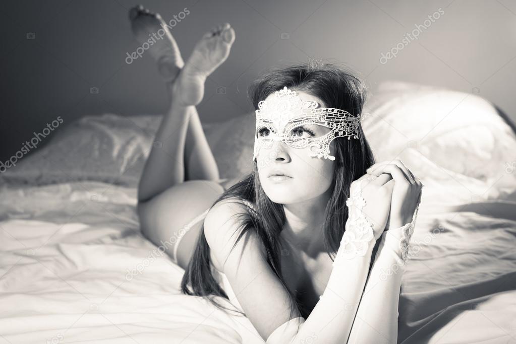 Beautiful young lady in lingerie relaxing in bed
