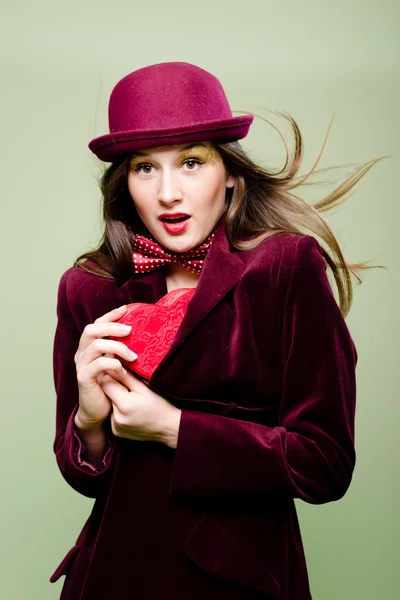 ハートの形の赤いコートのプレゼント ボックスの中に隠れて若い女性 — ストック写真