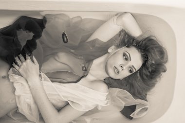 Blond elegant young lady laying in clear water