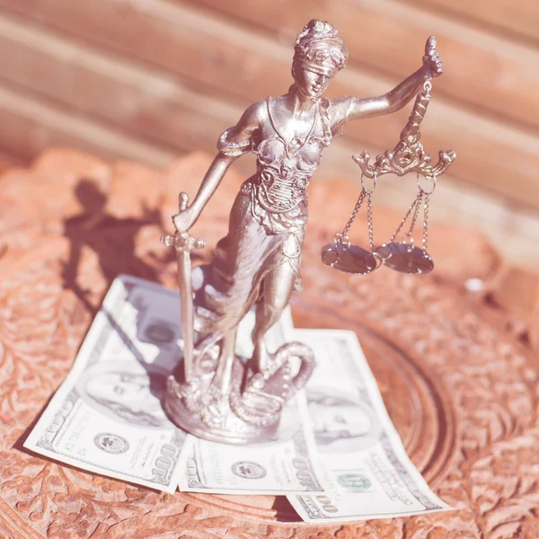 Деньги и справедливость: скульптура их, фемиды или богини правосудия, стоящей на деньгах, подкупает символ коррупции — стоковое фото