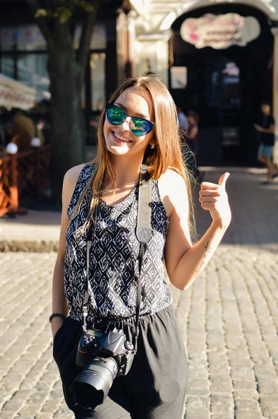 Stylish pretty modern girl with camera doing tourism in city — Stok fotoğraf