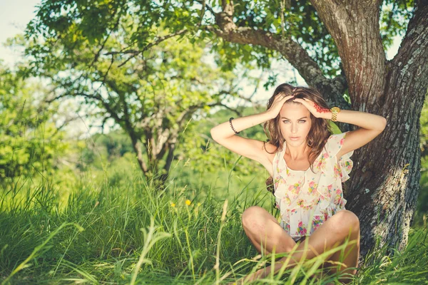 Портрет обеспокоенной женщины, сидящей под деревом — стоковое фото