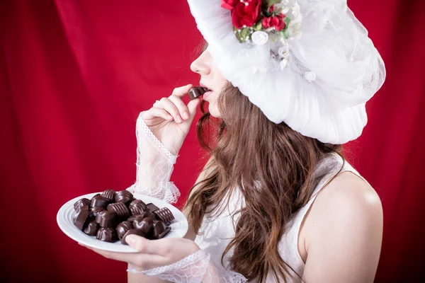 Bella signorina in bianco cappello retrò mangiare cioccolato — Foto Stock