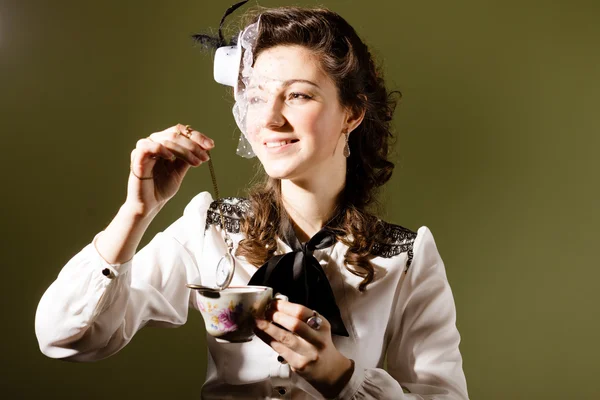 Portrait de jeune femme mettant montre chaîne dans la tasse — Photo