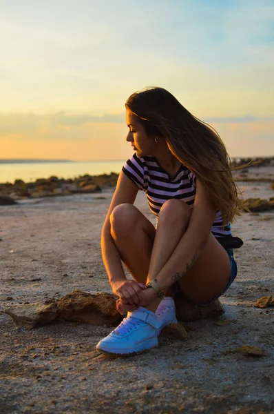 Sexi junge Frau sitzt am Strand am Meer — Stockfoto