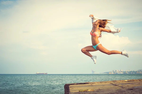 Increíble bailarina en traje de baño saltando alto en la playa — Foto de Stock