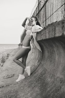 Black and white picture of sexi young female standing by floodboard 