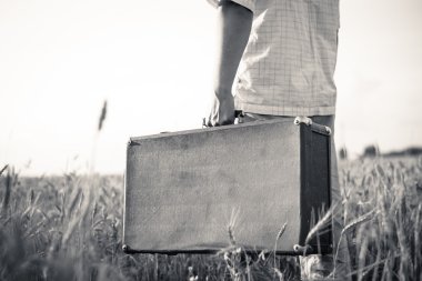 Black and white picture of mans hand   holding retro suitcase