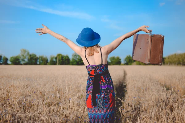Carefree female in sundress and bowler hat holding retro suitcase — ストック写真