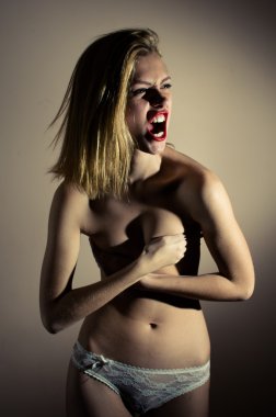 Picture of screaming beautiful blond young woman posing topless hiding covered topless chest looking at  on light background copy space clipart