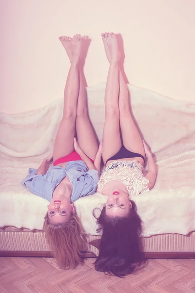 2 glamor blond and brunette sexy girlfriends with red lips having fun lying in bed together — Stock Photo, Image