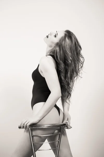 Foto en blanco y negro de la hermosa mujer joven sexy con cuerpo perfectamente en forma mirando hacia arriba — Foto de Stock