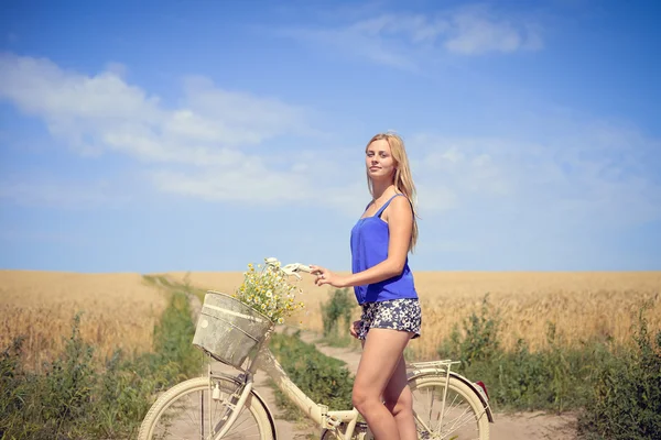 Retrato de bela jovem loira com ciclo no campo de trigo ao ar livre espaço de cópia de fundo — Fotografia de Stock