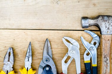 Toolkit with hammer, set of wrenches over wooden background copyspace