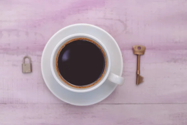 Closeup picture of cup of coffee with lock and key as symbol freedom — Stockfoto