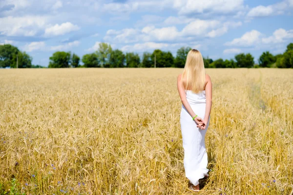 Schöne schlanke sexi blonde Dame im weißen langen Kleid zu Fuß weg. — Stockfoto