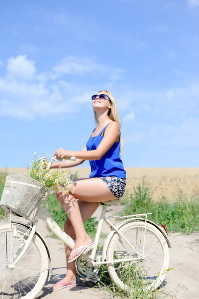 Portrait of beautiful young lady travel with cycle on the wheat field and blue sky outdoors copy space background — Stock Photo, Image