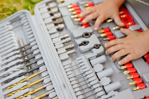 Young hands on drill bits. Closeup picture — Stockfoto
