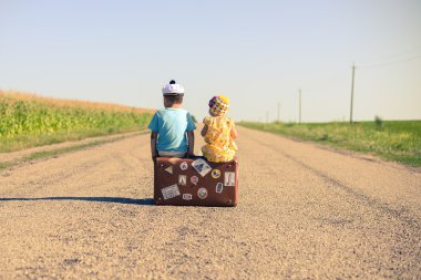 bavula kırsal kırsal yolda güneşli mavi gökyüzü açık havada arka plan, alan resim kopyalama üzerinde oturan çocuklar silüeti