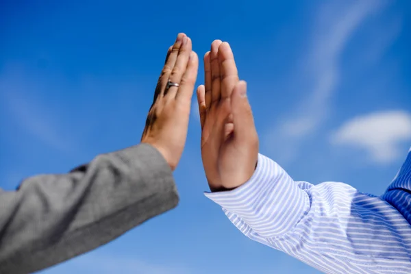 Hombre y mujer de negocios dando cinco, cerca de detalle de las manos. Dos manos aplauden bajo el cielo azul . — Foto de Stock