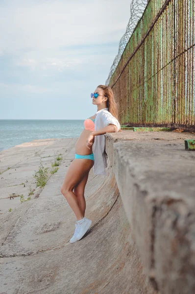 Jovem senhora de roupa de banho encostada nos cotovelos contra o mar — Fotografia de Stock