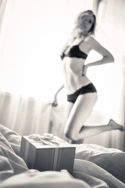 Closeup on pink gift box present with one elegant blonde pinup pretty female in underwear having fun posing relaxing standing on light copy space background, black and white portrait — 图库照片