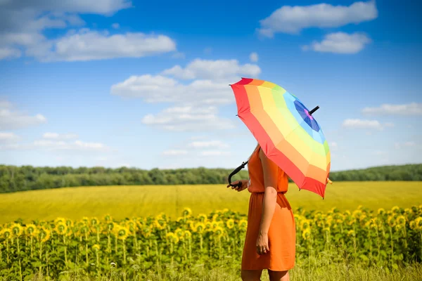 Female under umbrella standing in field of sunflowers — Stock Photo, Image